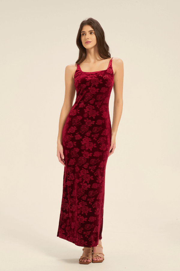 Model wearing a sleeveless red velvet slip dress with rose pattern, front full-length view.
