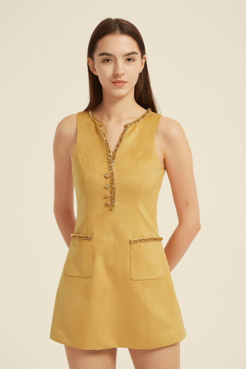 Front view of a sleeveless yellow mini dress featuring a V-neckline with beaded trim, decorative front buttons, and flap pockets with matching beaded accents.