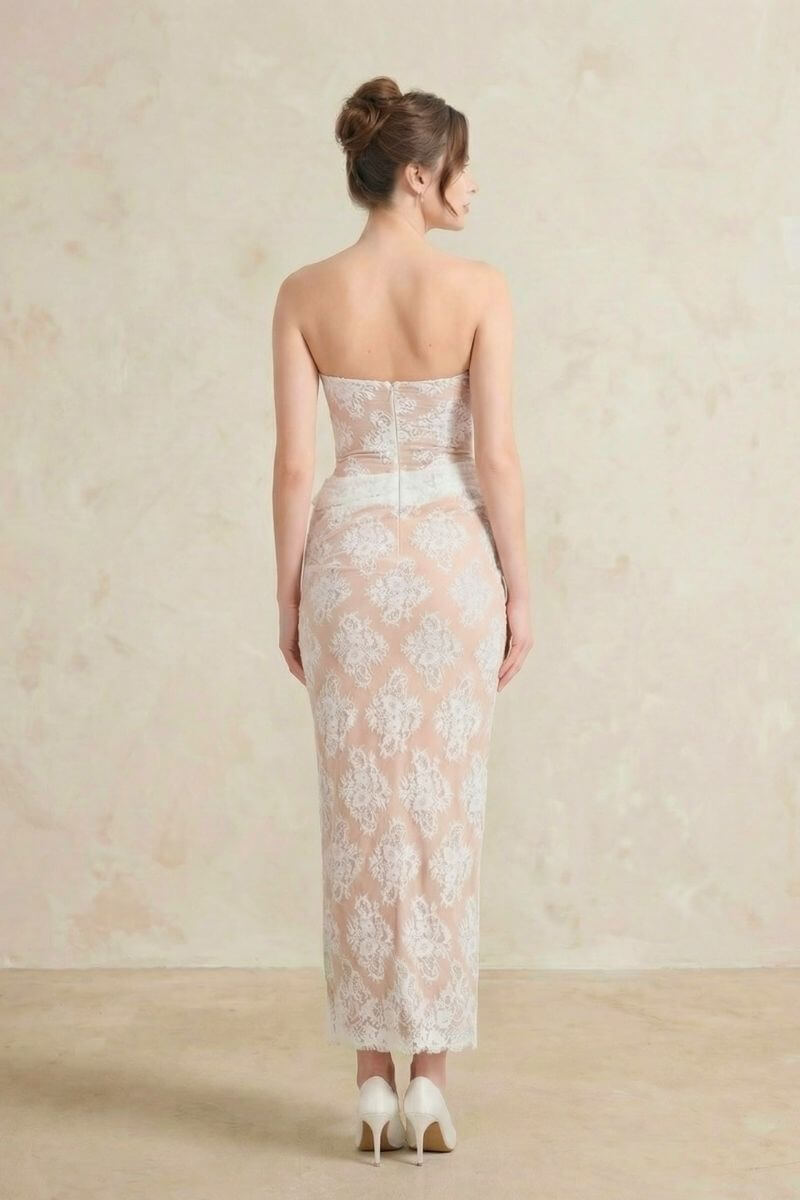 The back view of a strapless white lace corset maxi dress, featuring a fitted silhouette, floral lace overlay, and a clean zip closure.