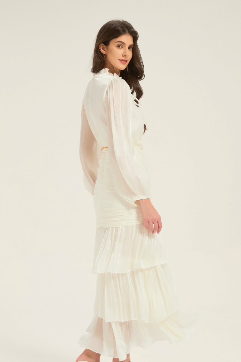 Side view of the white ruffle tiered midi dress with pearl belt, designed with a flowing layered skirt and elegant long sleeves.