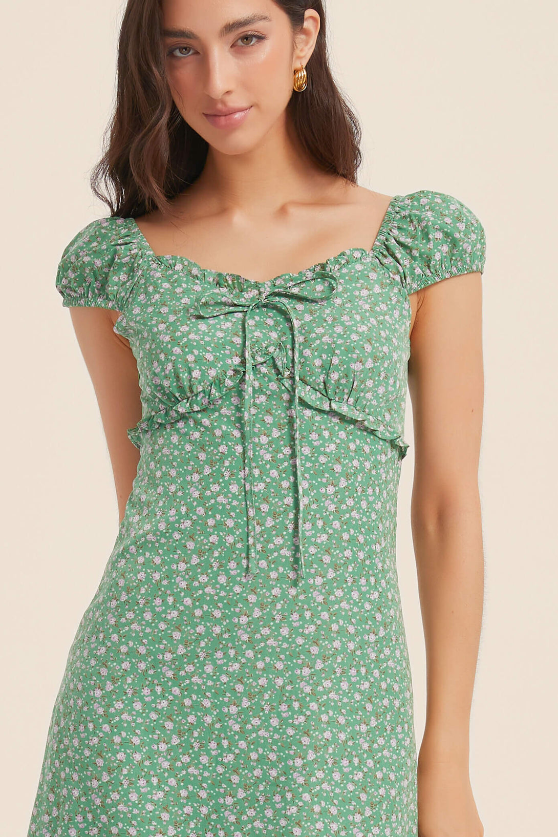 Close-up of the bust and neckline on green floral ruffle midi dress with ruched detail and adjustable tie-front