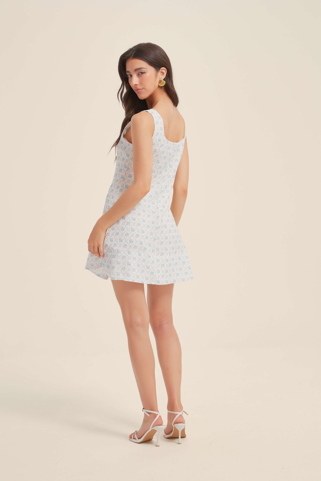 Back view of sleeveless blue floral mini dress with a flared skirt and square neckline