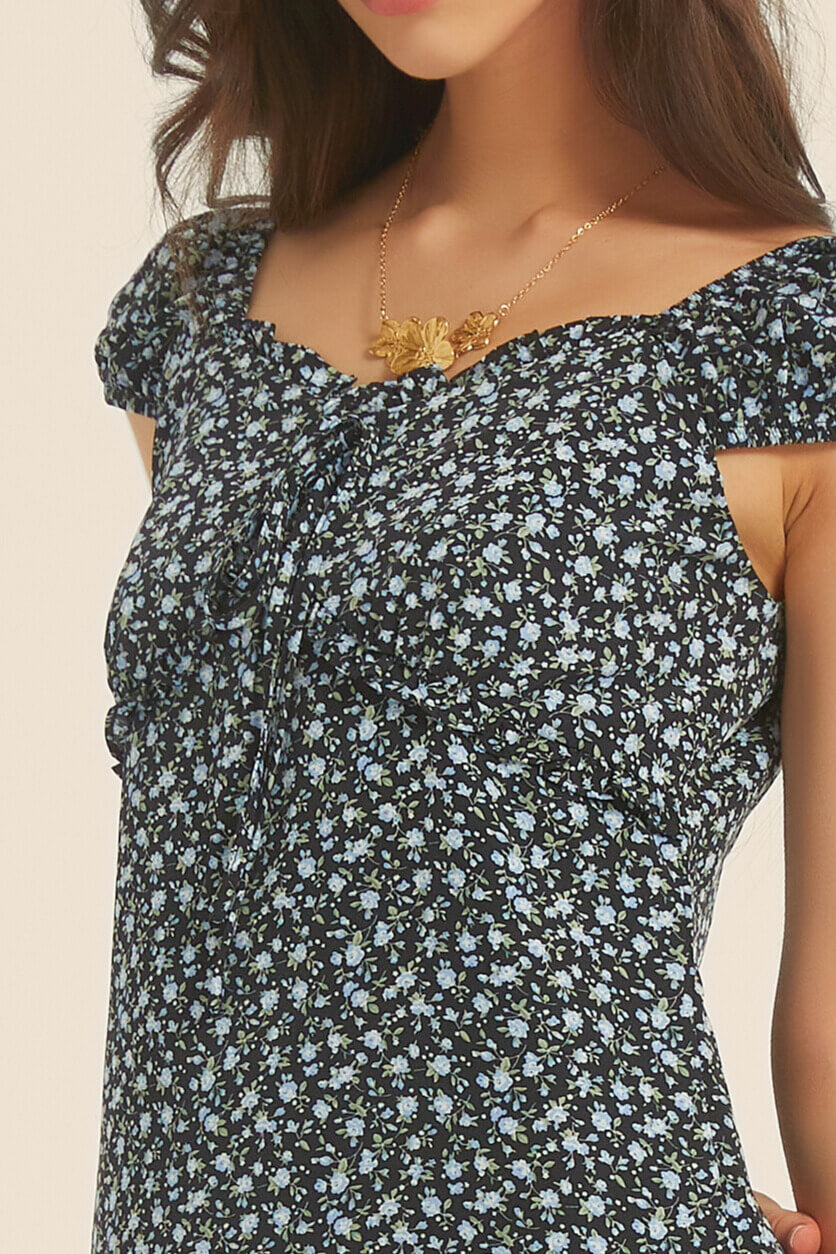 Close-up of the bust and neckline on black floral midi dress with ruched ruffle trim and sweetheart shape

