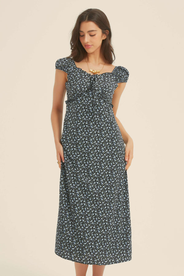 Woman wearing a black floral midi dress with cap sleeves and sweetheart neckline, ideal for casual summer outings and weekend wear
