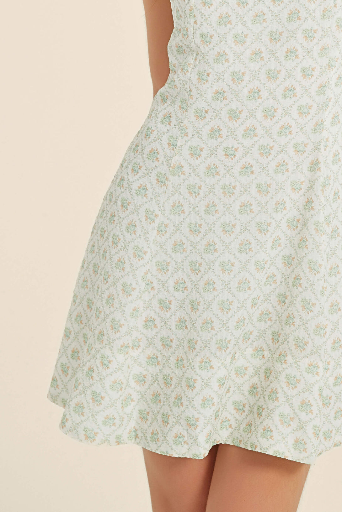 Close-up of green floral mini dress with soft A-line skirt and vintage print