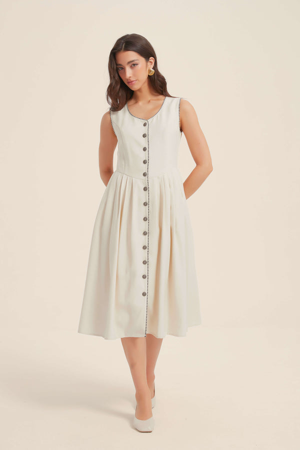 Woman wearing a white button-down midi dress with sleeveless cut and black trim details, front view.